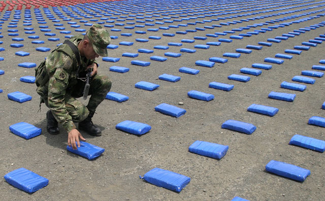 A Colombian soldier poses with a pack of marijuana confiscated by army troops near Cali city. At least 2 tonnes of marijuana were seized during an anti-drugs raid, authorities said