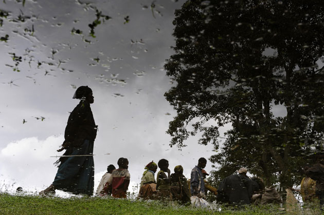 People are seen reflected in a pool as they line up during a food distribution in Buge village, Wolayita region in southern Ethiopia. The United Nations appealed on Monday for $460 million to feed some 10 million Ethiopians hit by drought and high food prices.